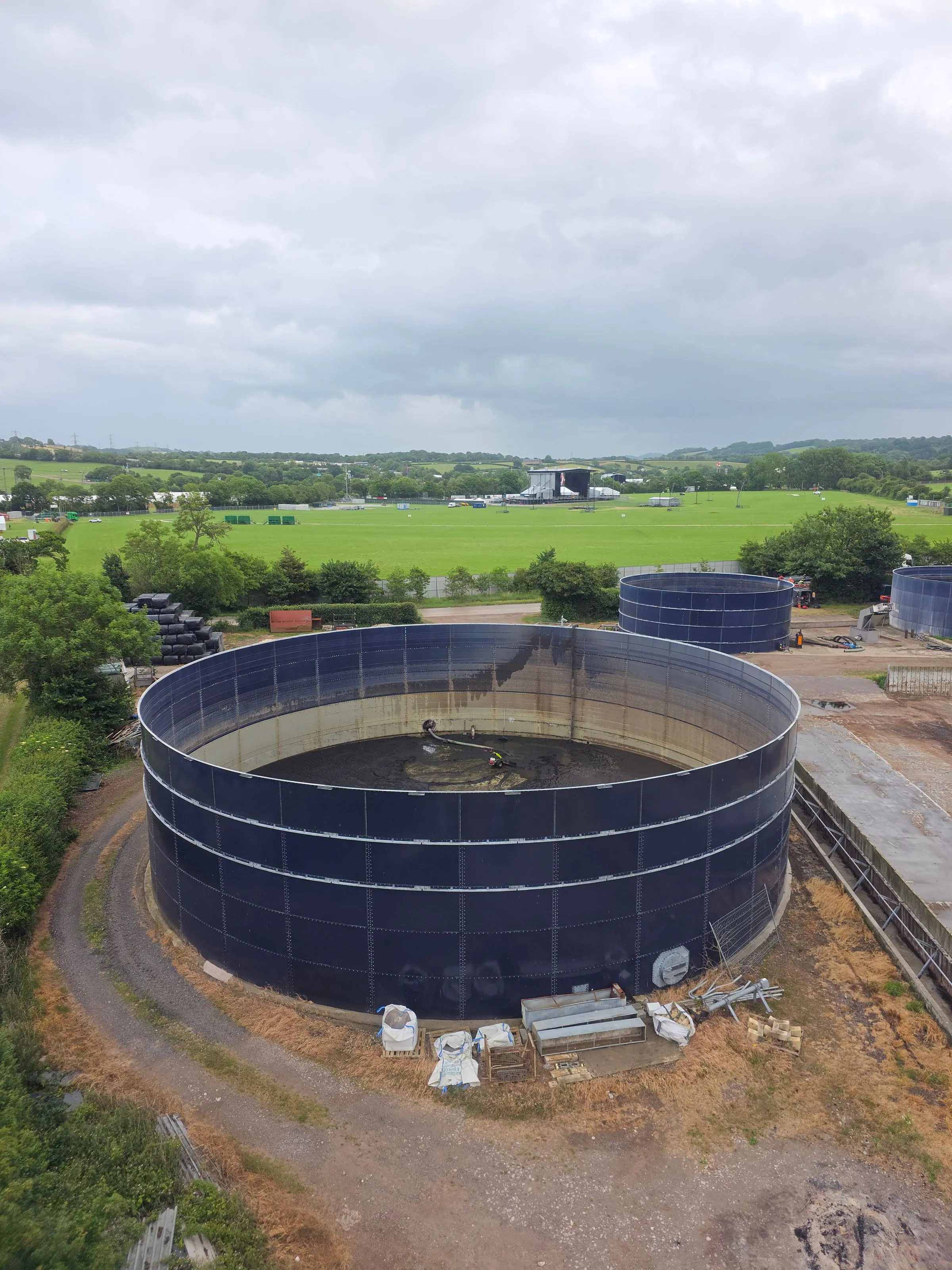 Industrial tank farm with liquid storage tanks monitored by ultrasonic and radar level sensors